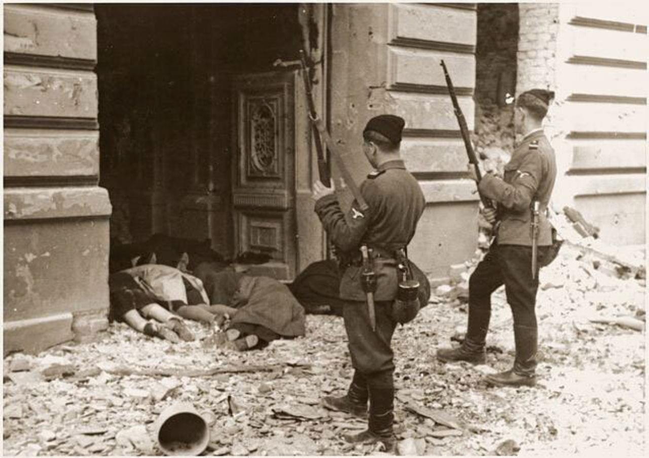 Dva ukrajinští členové SS nad těly Židů zavražděných při povstání ve varšavském ghettu. Zdroj: Polský národní archiv